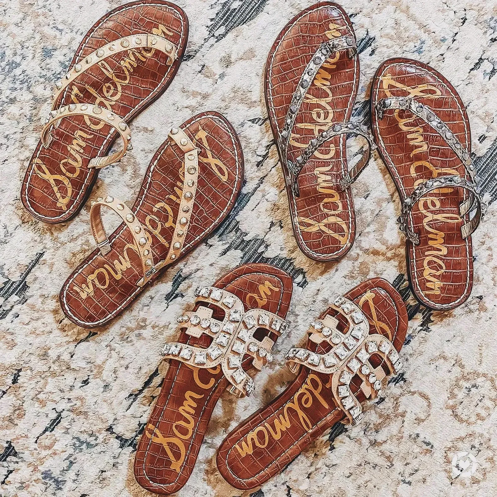 Various studded sandals on a carpeted surface