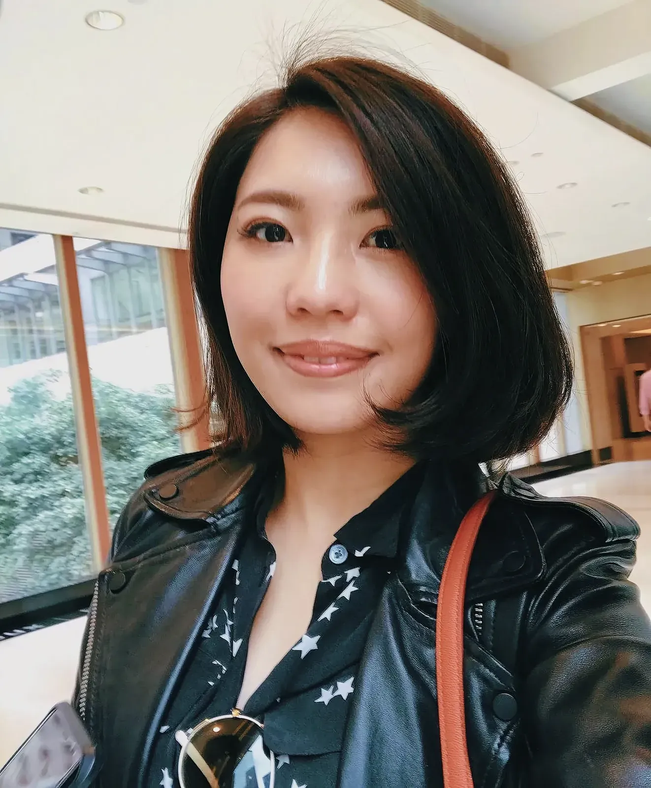 Stylish woman in black leather jacket taking a selfie