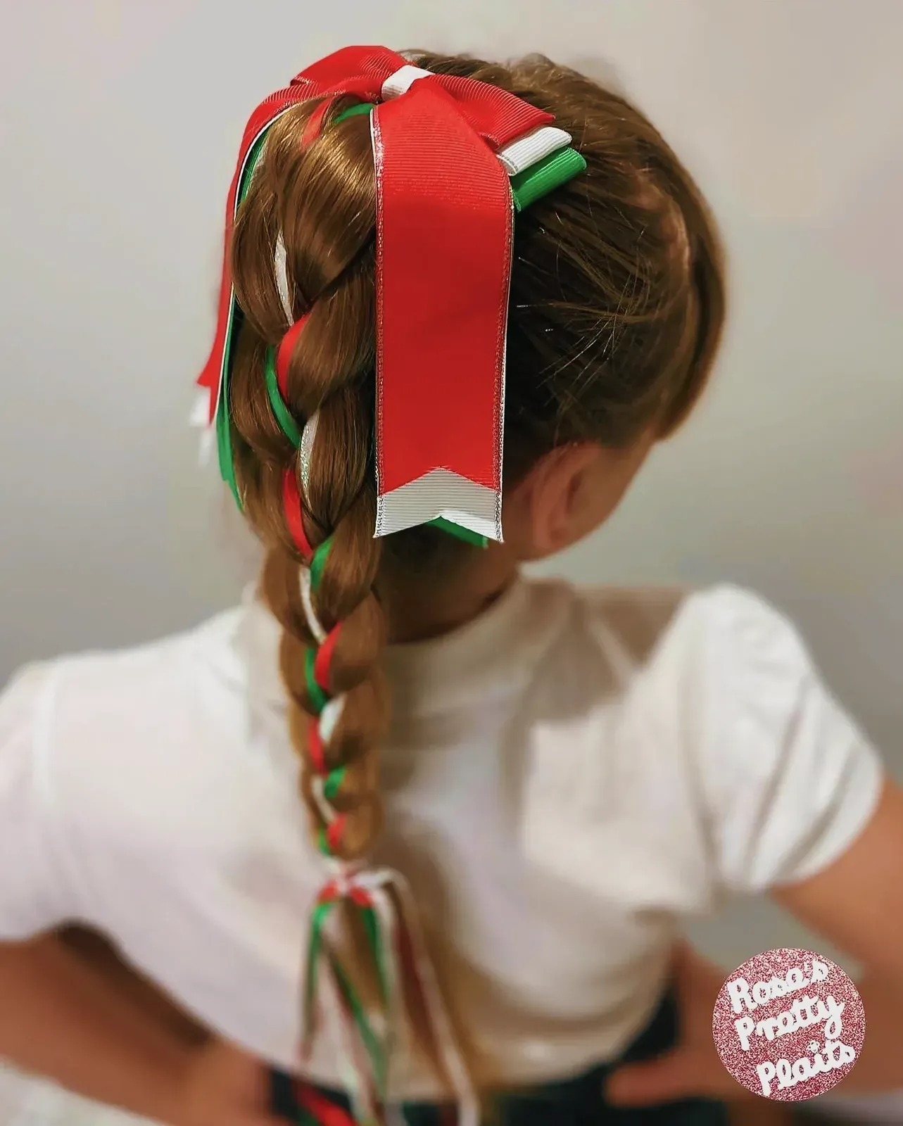 Young girl with a red and white ribbon braid hairstyle