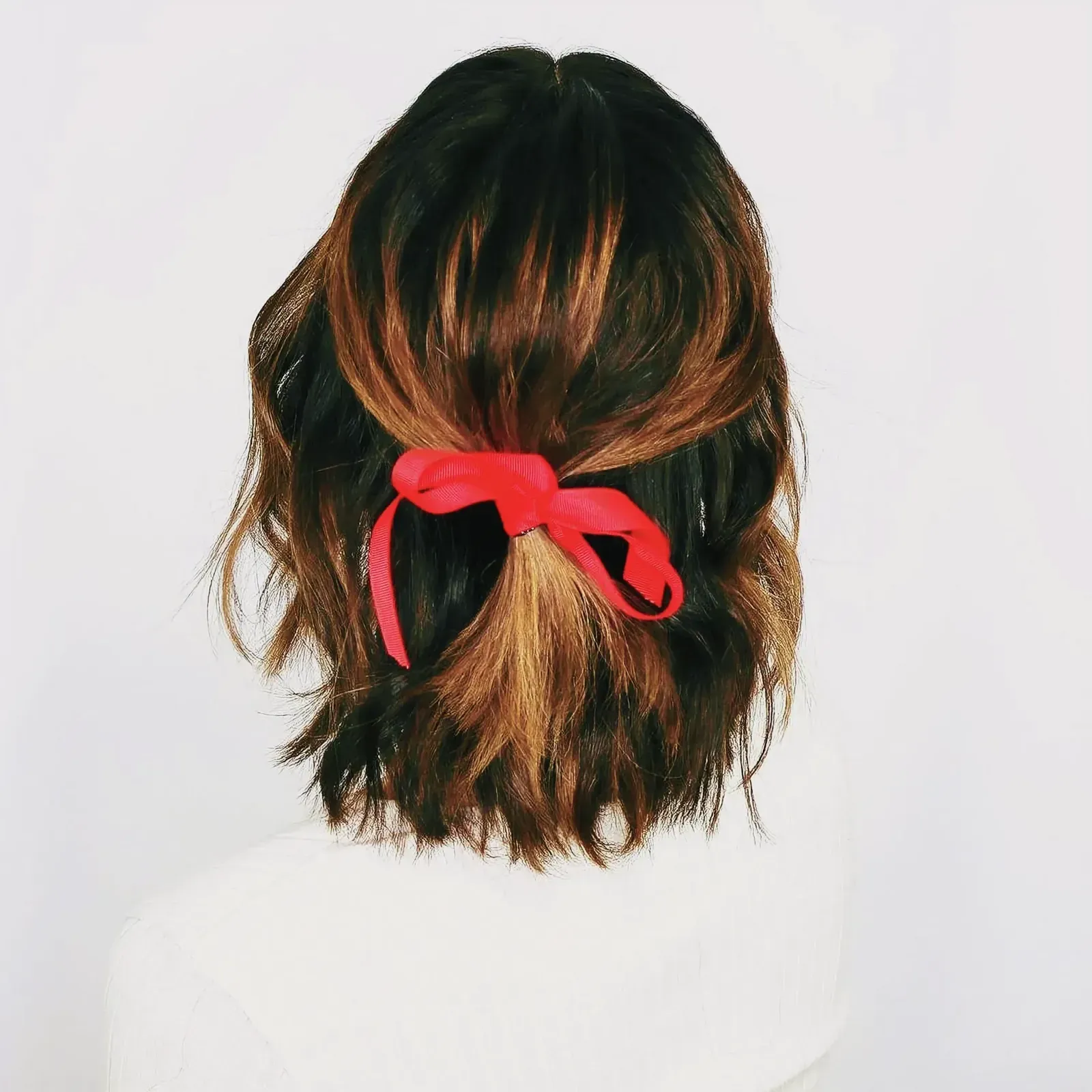 Stylish woman with vibrant red bow in her hair