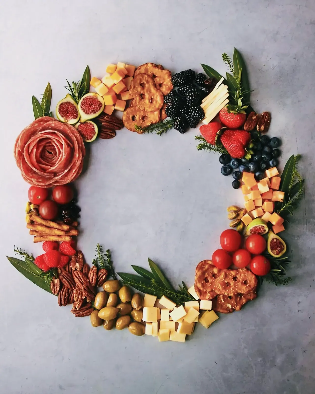 Beautifully arranged circular display of various foods inside a floral wreath