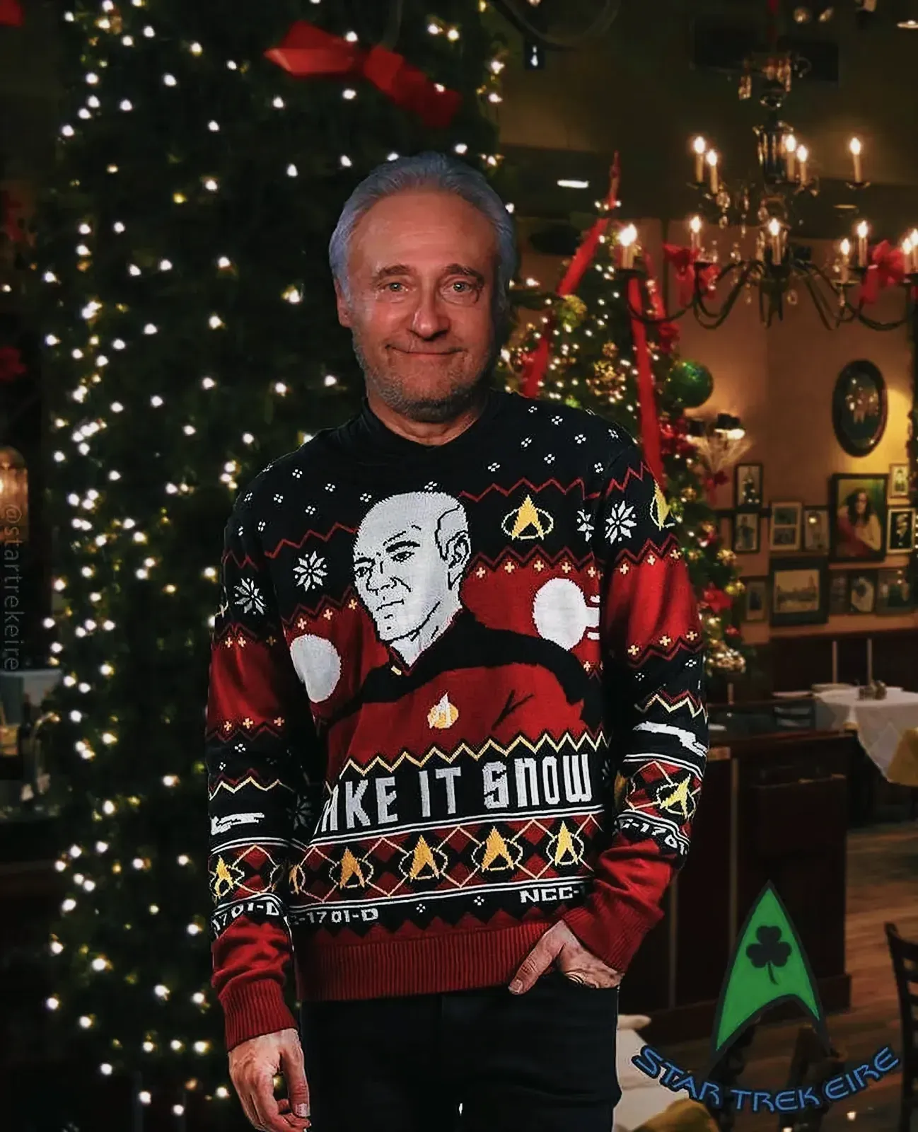 Man wearing a festive Christmas sweater adorned with traditional holiday elements.