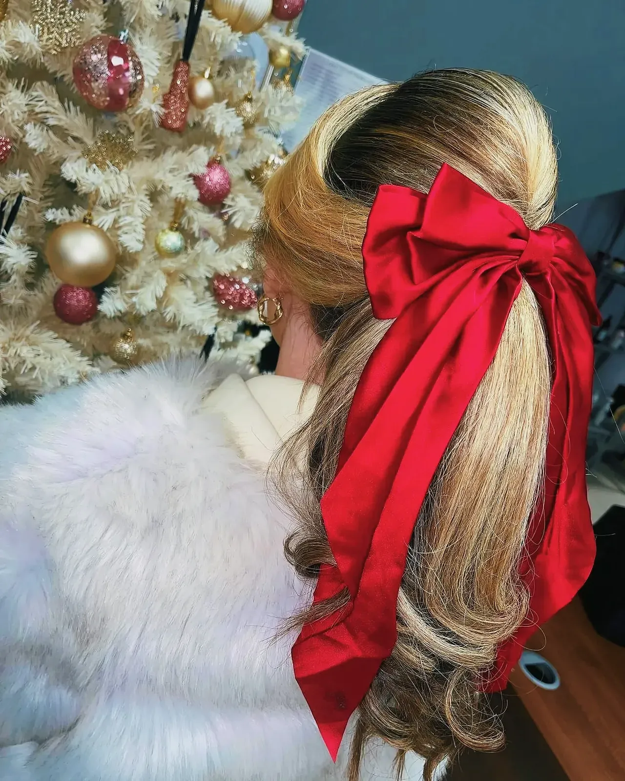 Festive Christmas hairstyle with a fashionable woman wearing a red bow