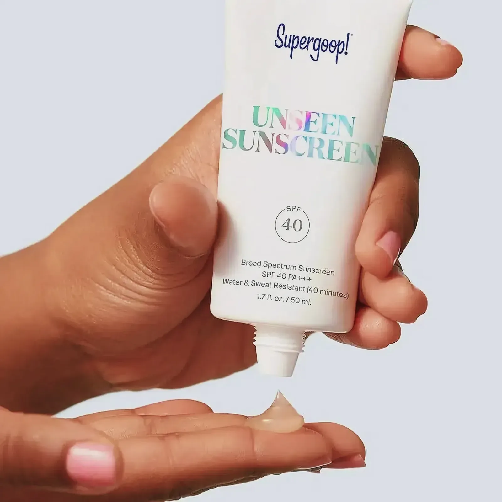 Close-up of a hand holding a tube of Supergoop! Unseen Sunscreen SPF 40 PA+++