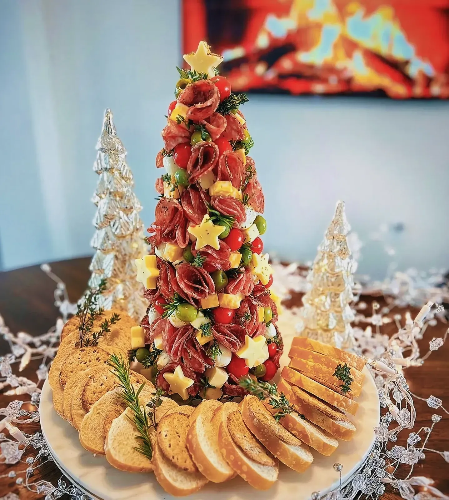 Close-up of a Christmas tree made of baked goods surrounded by an array of delicious finger foods.