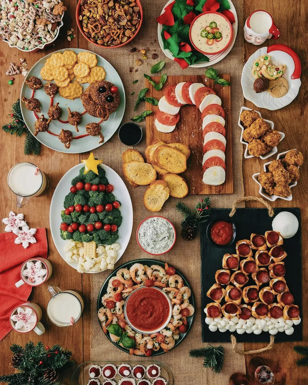 A festive spread of Christmas finger foods including shrimp cocktail, pizza, mixed nuts, and more.