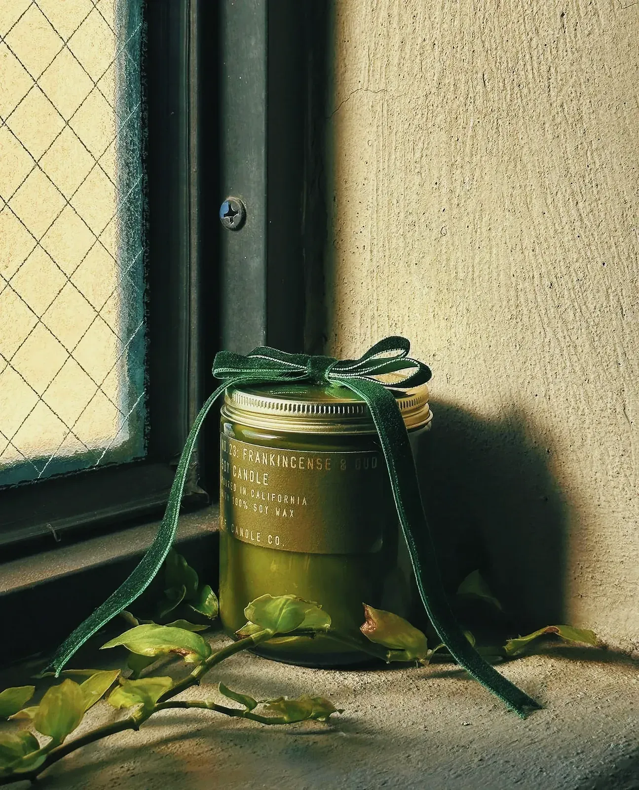 Vibrant green candle in a jar with a bow