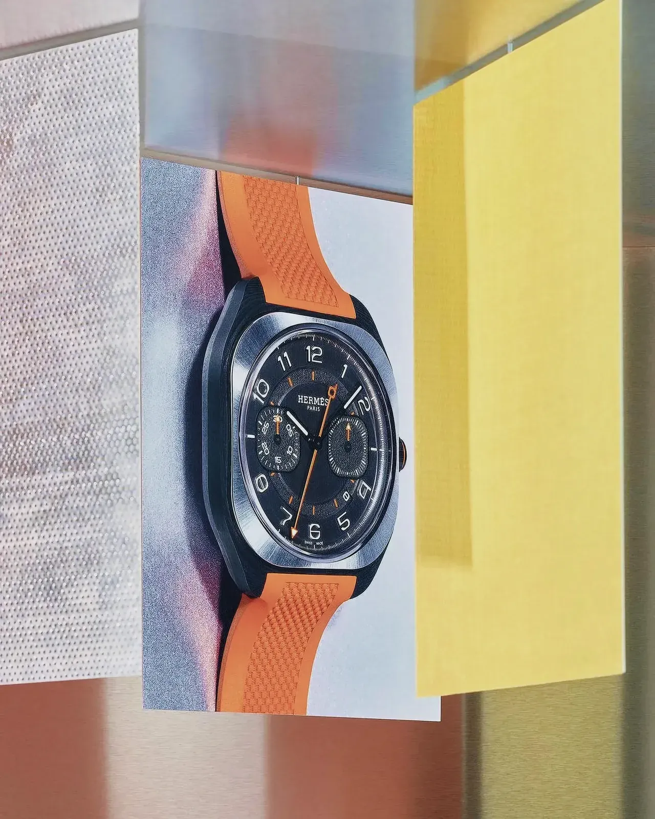 Analog watch on display with yellow wall in the background