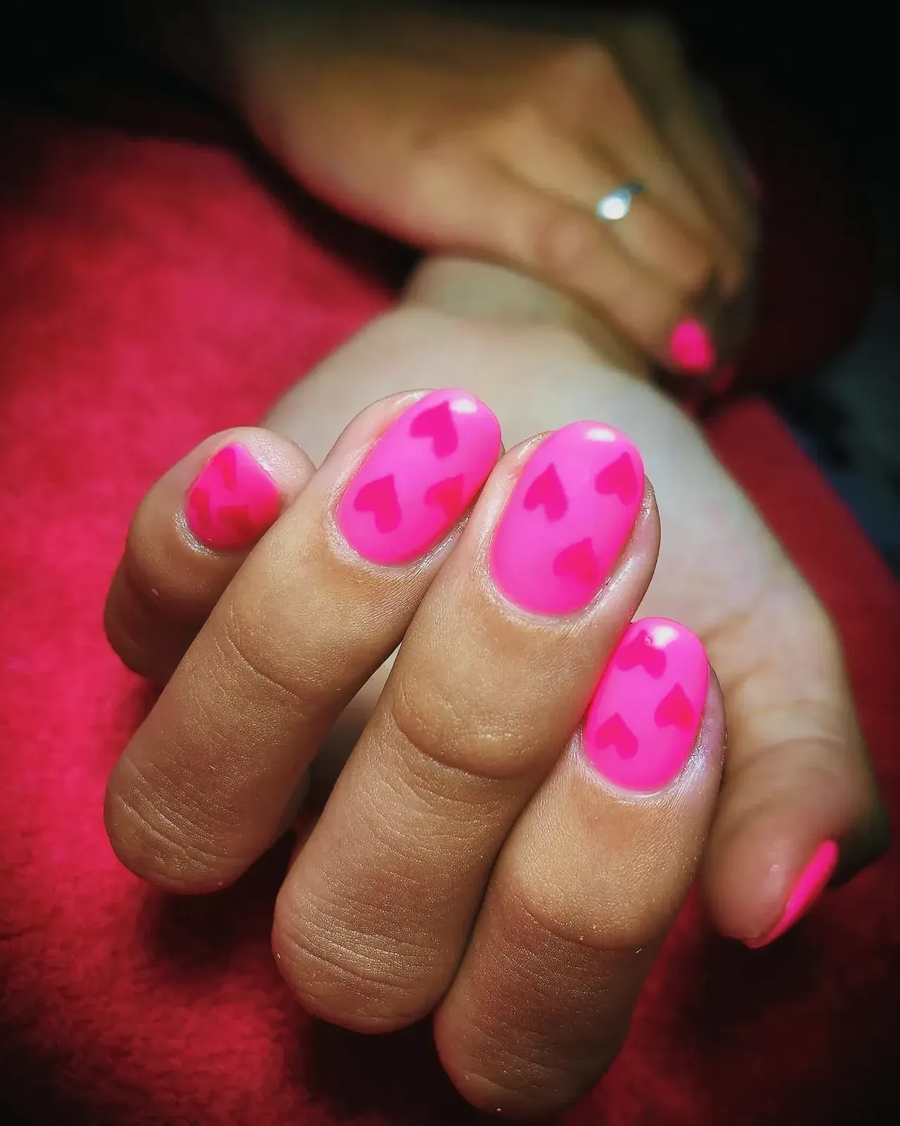 Close-up of beautifully painted pink nails with heart designs