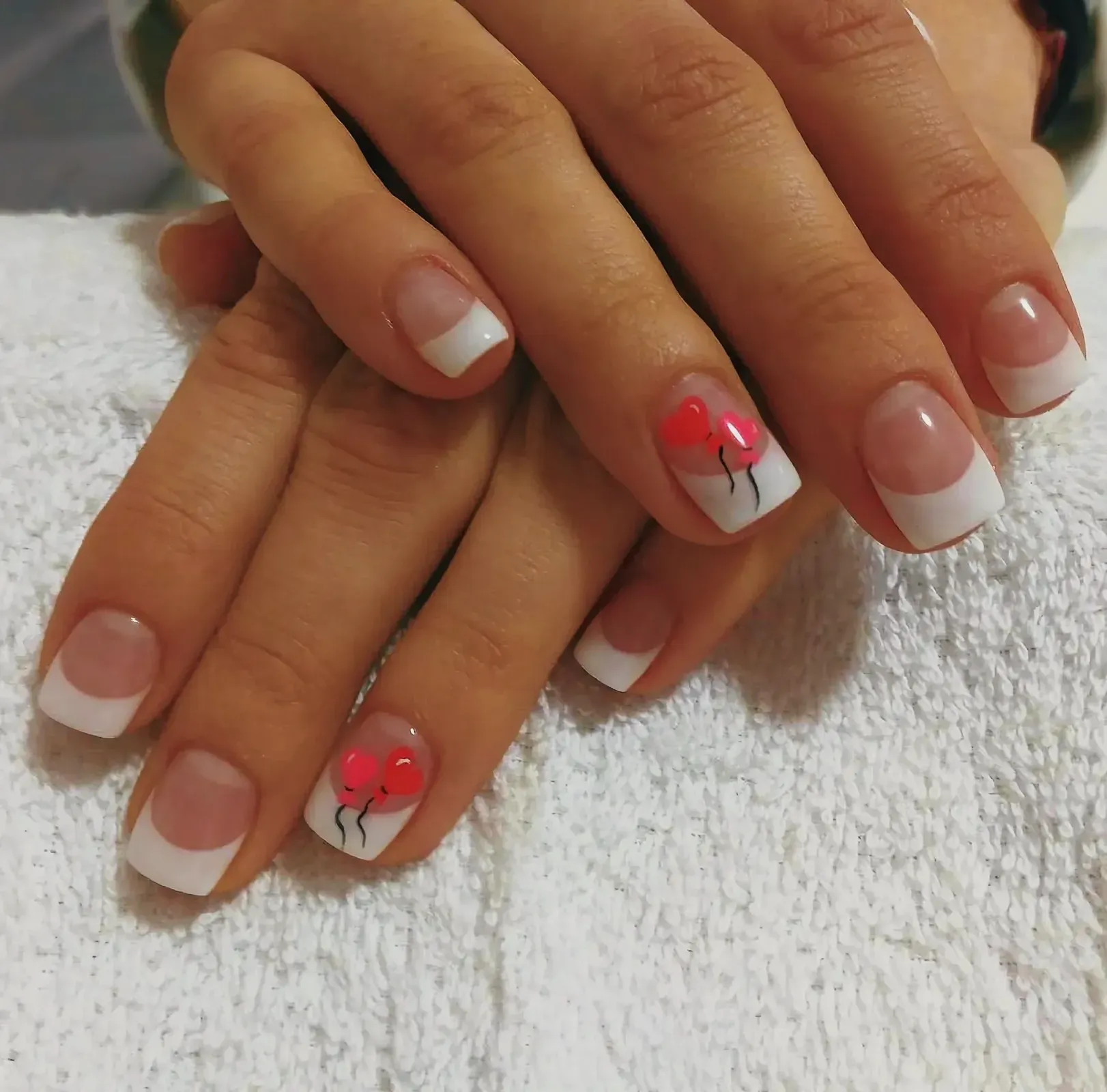 Close-up view of beautifully painted nails with red heart design