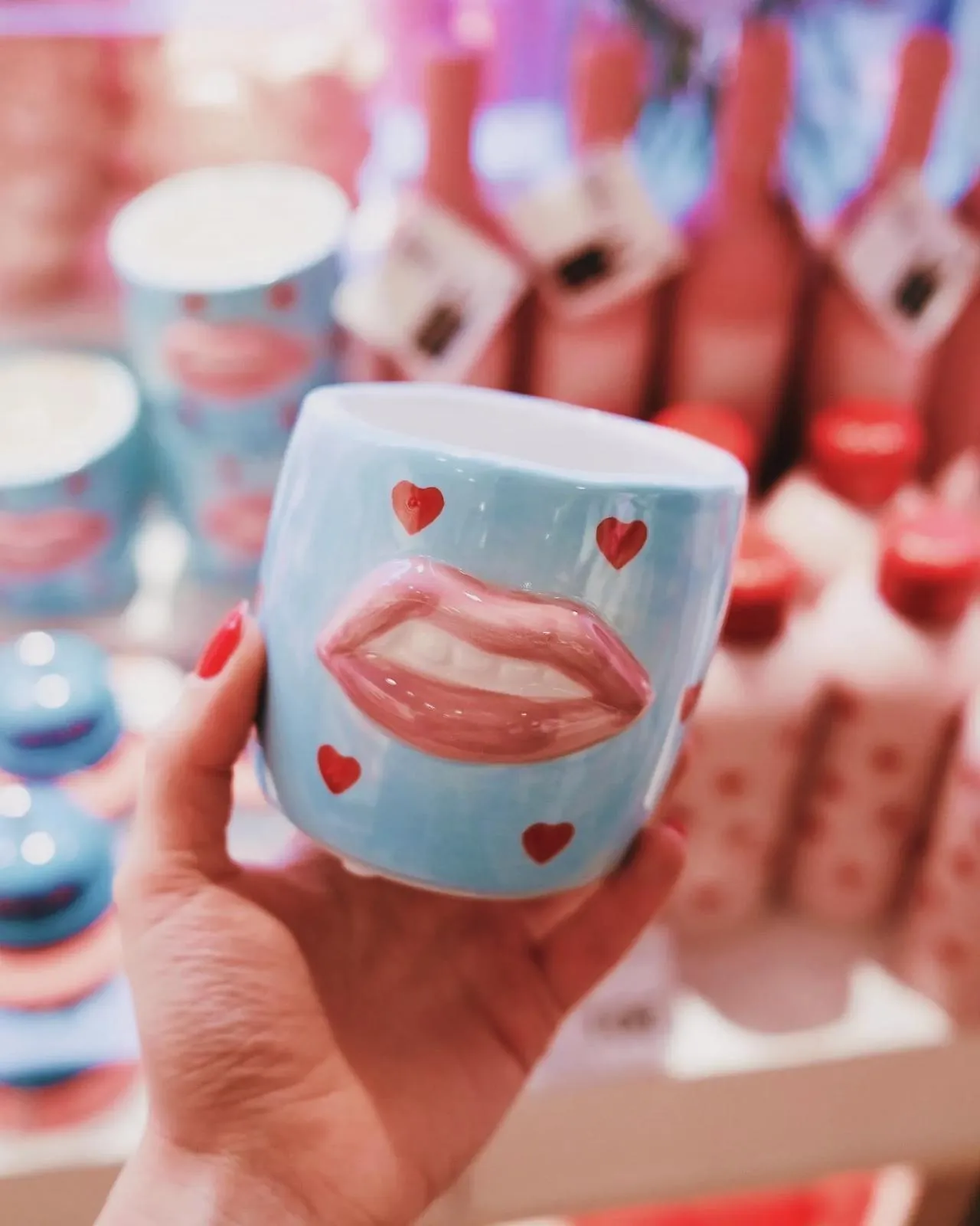 Hand holding a charming blue mug with lips design